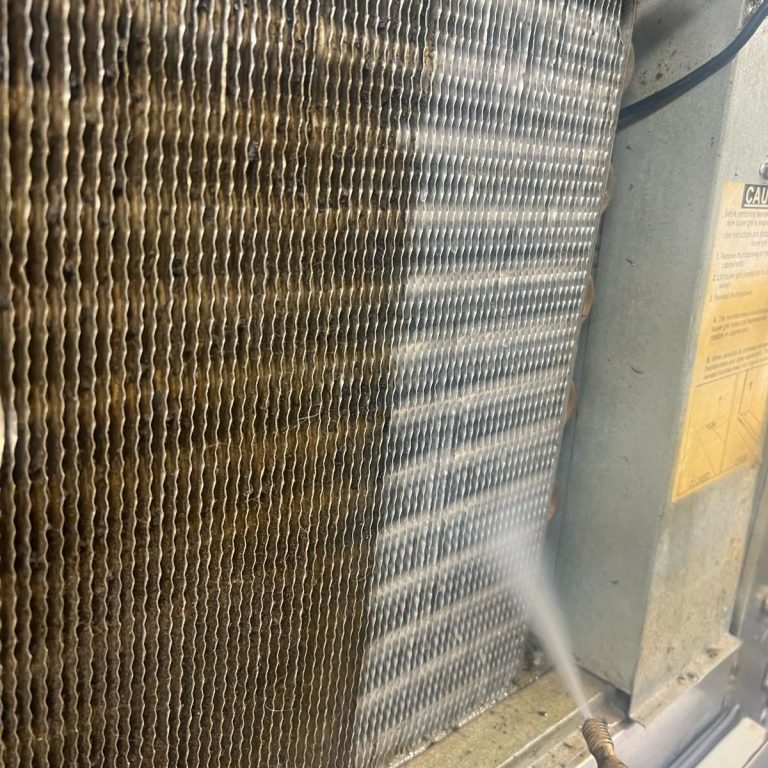 A close-up of a cooling coil being cleaned with water.